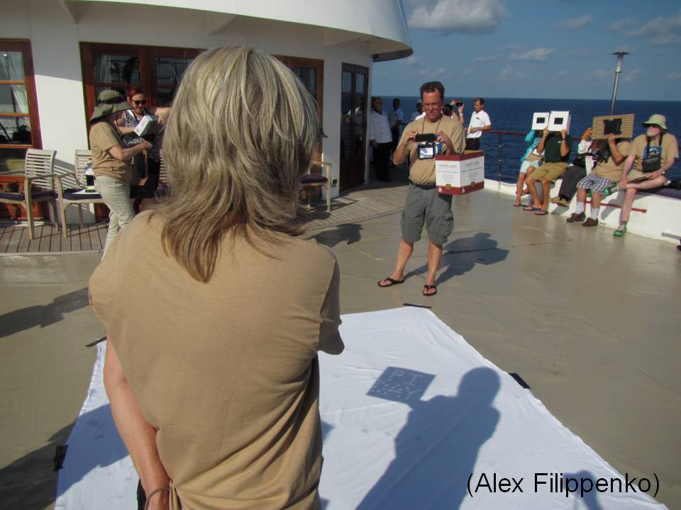 Pi day sign held up so as to cast shadow focusing on white sheet taped to boat deck.